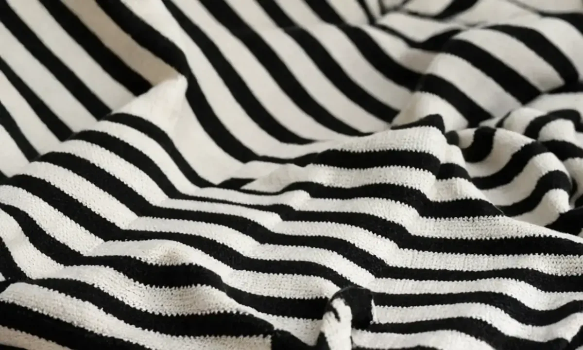 A striped pattern adorns a square cloth with an impactful weave element